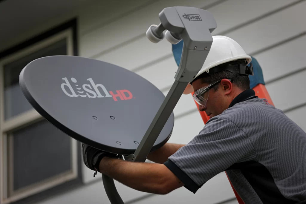 A technician fixing the position of the Dish antennae 