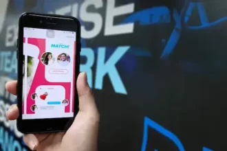 A man holding a phone with tinder match on screen