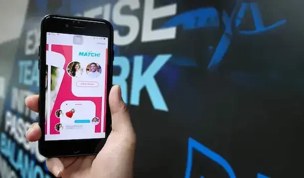 A man holding a phone with tinder match on screen