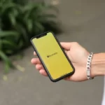 A man holding a phone with Bumble app open