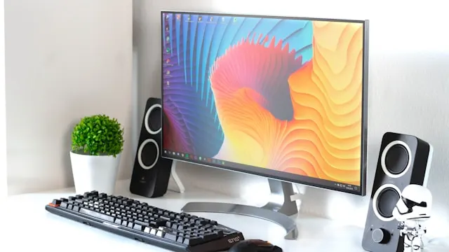 monitor with keyboard and speaker on table